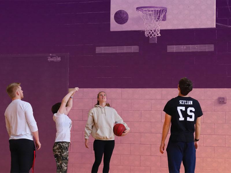 两个女人和两个男人在体育馆打篮球
